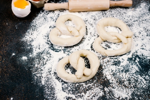 raw pretzel and ingredients eggs flour and ears of wheat - Пасхальные крендельки