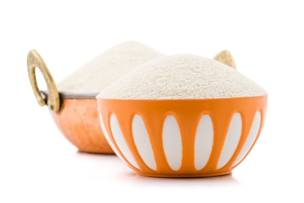 raw unprepared semolina flour or suji on white background - Постные блинцы из манки с луком и морковью