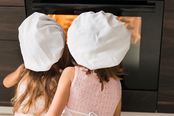 rear view of two kids in chef hat looking at cookie tray in oven - Кекс "Пасхальный ягненок"