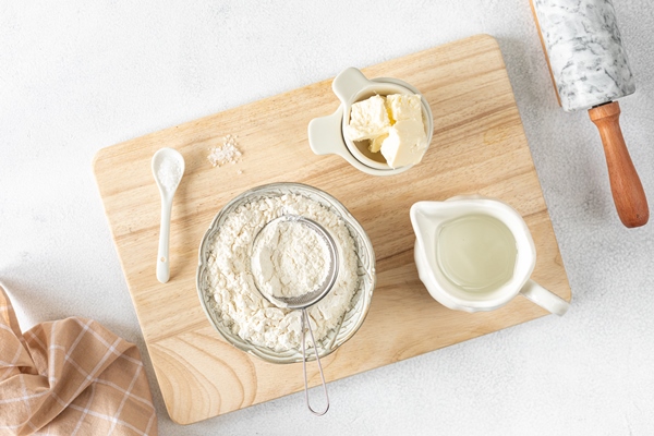 recipe step 1 ingredients for home baking the concept of baking is a marble rolling pin flour butter water on a white background top view flat lay 1 - Песочный пирог без яиц
