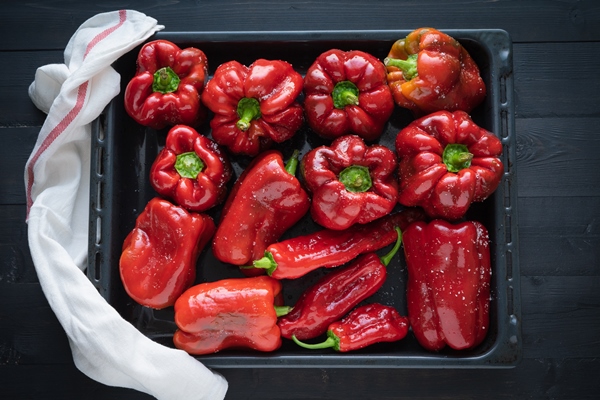 red peppers on a tray ready to bake - Салат из печёного перца с цветной капустой