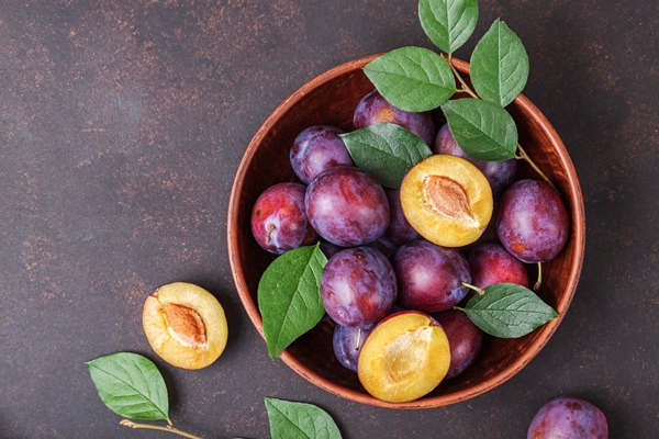 ripe plums with leaves on table summer fruit background plum view top flat lay - Слива в собственном соку