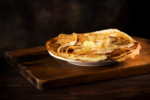 russian pancakes crepes with butter on rustic wooden background - Постные блинчики с рисом и рыбой