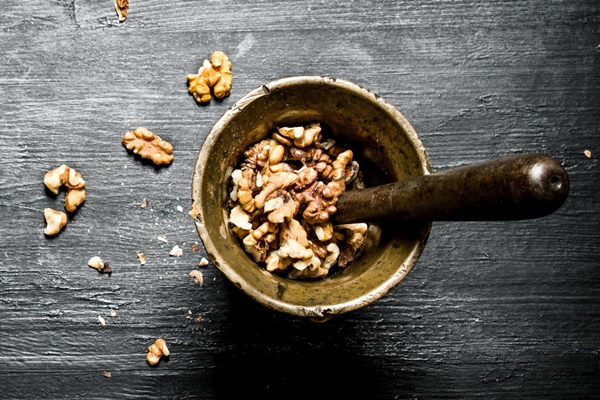shelled walnuts in a mortar with pestle on black rustic table 1 - Постные блинчики со свёклой и орешками