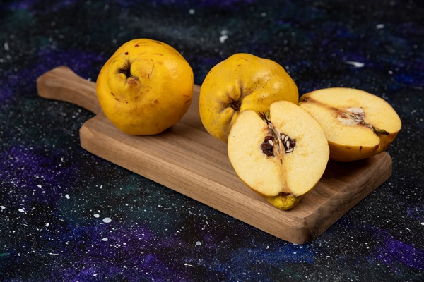 sliced and whole fresh quince fruits on wooden board - Мармелад из айвы