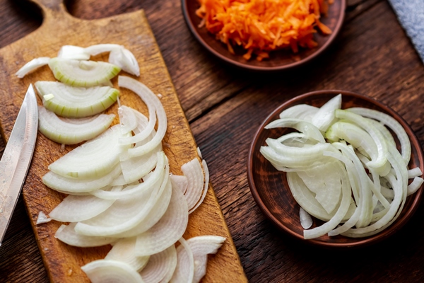 sliced onions and carrots on a dark wooden background ingredients preparation for cooking - Постные блинчики с картофельной начинкой