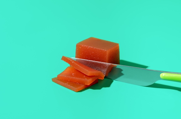 slicing quince marmalade on a blue background - Повидло из айвы