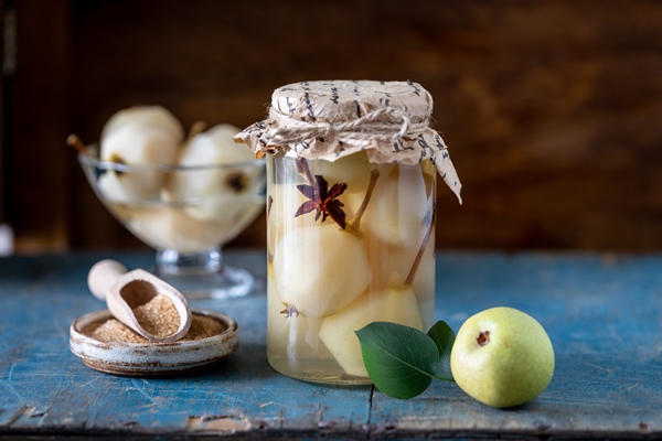 stewed pears jar of sweet pears stewed in syrup on a dark background festive dessert - Целые груши в сиропе