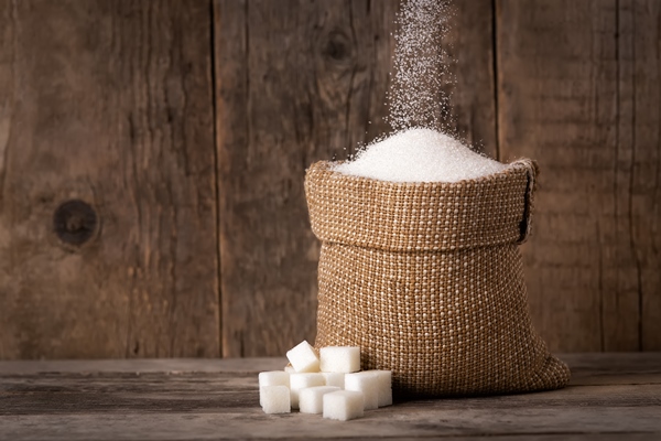 sugar falling in sack on wooden background - Кизиловый компот