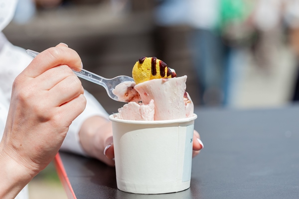 thailand stir fried ice cream rolls in a mug in a female hand - Мороженое из клюквы