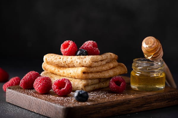 thin homemade pancakes with berries and honey closeup - Постные медовые блинцы на соевом молоке