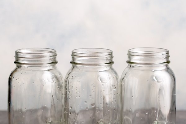 three empty clean canning jars with drops of water three empty clean canning jars with drops of water - Консервированные яблоки