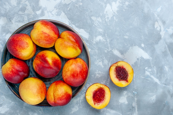 top view fresh ripe peaches delicious summer fruits on light white desk - Консервированные персики в сиропе