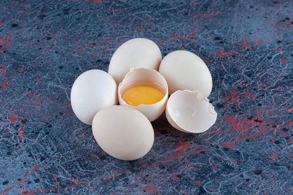 top view of fresh white chicken egg broken with yolk and egg white - Творожное суфле