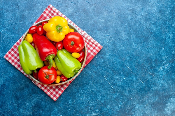 top view various vegetables cherry tomatoes different colors bell peppers tomatoes cumcuat on platter on red white checkered kitchen towel on blue table copy place - Салат из сладкого перца с луком