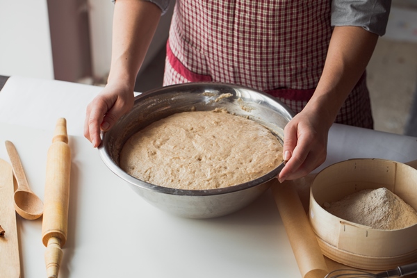 woman kneading dough on kitchen table - Кулич прозрачный