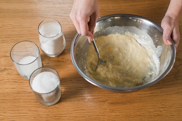 woman s hand mixing the baking dough in the stainless bowl - Блины по рецепту семьи Мейендорф