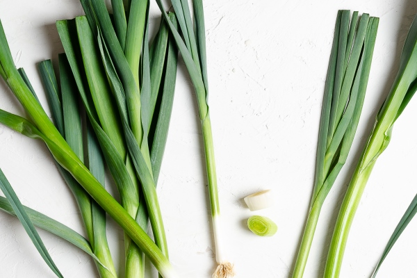 a bunch of fresh leeks on a white background - Салат зелёный