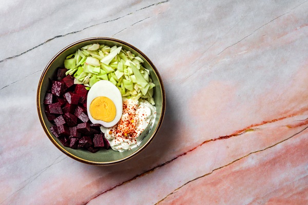 a healthy meal baked beetroot cabbage boiled egg greek yogurt and chili flakes overhead view copy space - Маринованная свёкла