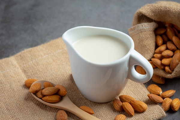 almond milk with almond on dark background - Яблоки с вареньем и миндальным молоком