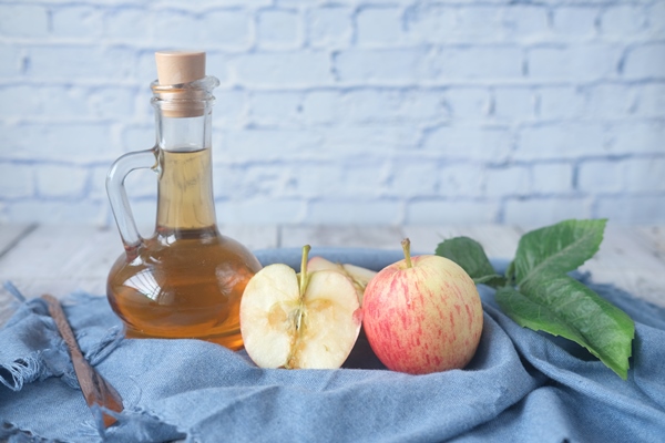 apple vinegar in glass bottle with fresh green apple on table - Осетрина варёная с хреном и уксусом