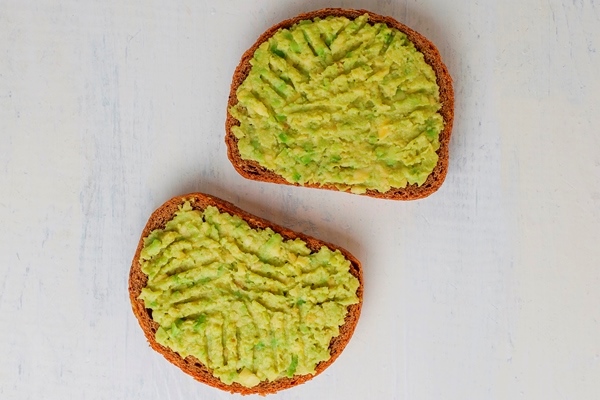 avocado toast on whole grain bread with vegetables - Бутерброд с яичницей, авокадо, чесноком и зеленью