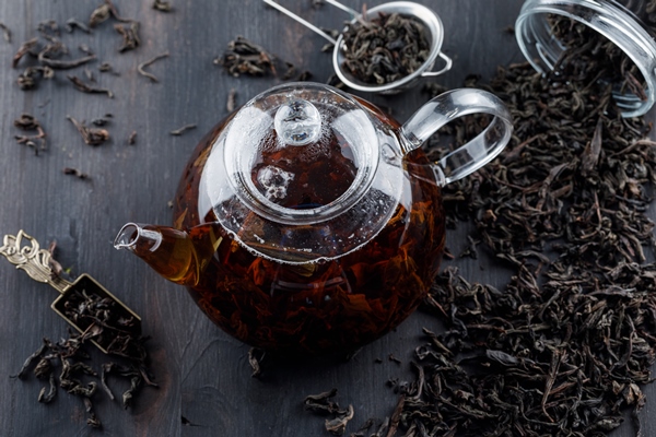 black tea with dry tea in a teapot on wooden surface - Праздничная коврижка