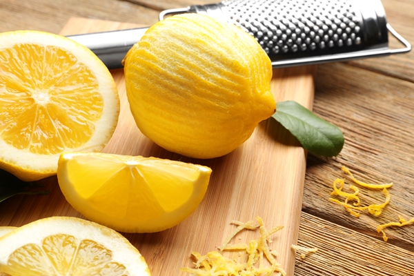 board with cut lemons and zest on wooden table closeup - Кисель ягодный