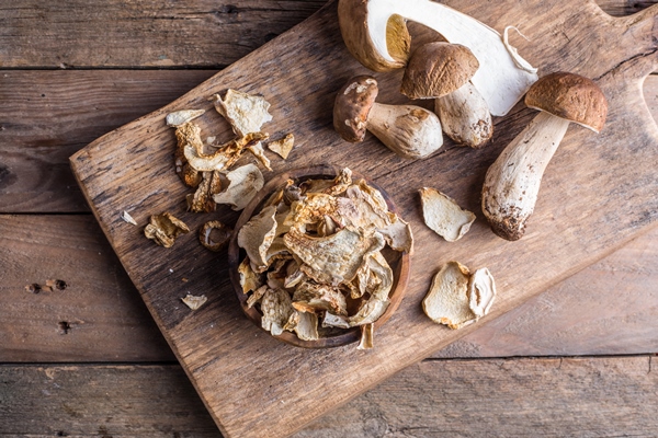boletus wild dried mushrooms set on old dark wooden table background - Котлеты рисовые c грибной начинкой