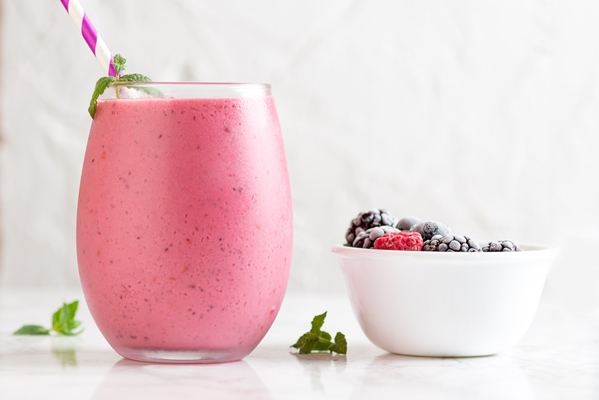 closeup shot of a delicious mix berry milkshake with different berries in a bowl next to it - Клюквенный мусс