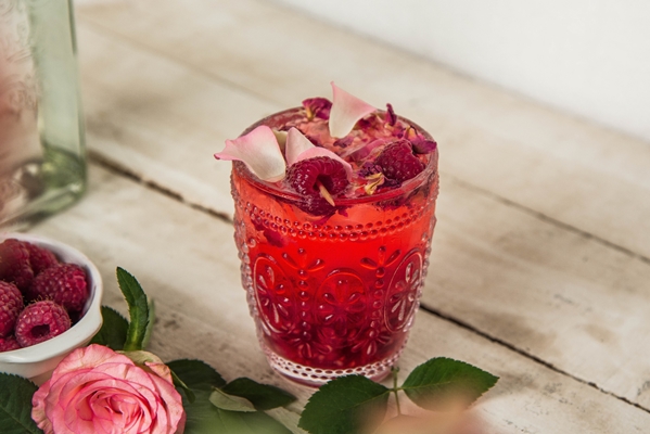 closeup shot of a glass with raspberry lemonade with dried flowers - Малиновый морс