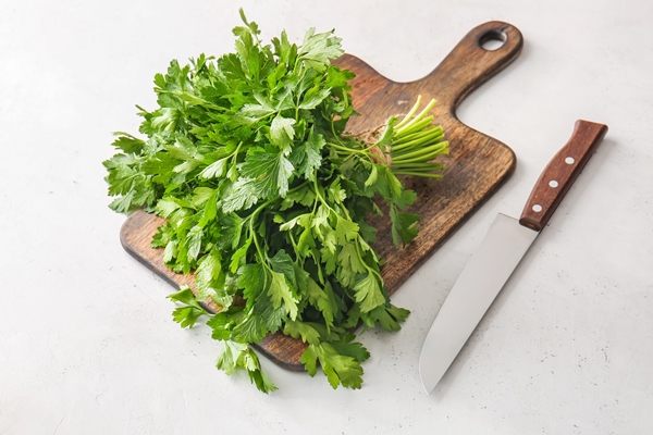 cutting board with fresh parsley and knife on table - Постный суп из свежих грибов с овощами
