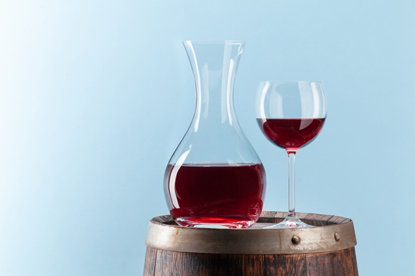 decanter with red wine on old wooden barrel - Маседуан из смеси свежих плодов