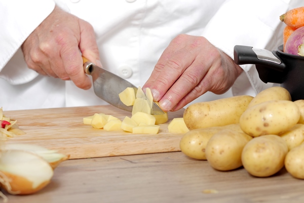 detail of hands of chef slicing potatoes - Сныть с тушёным картофелем