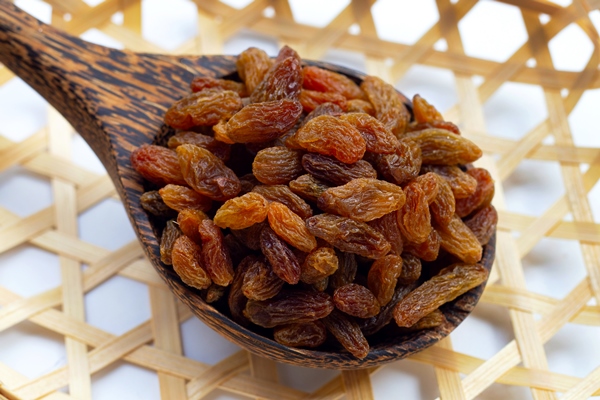 dried grape raisins in wooden spoon - Дрожжи из изюма