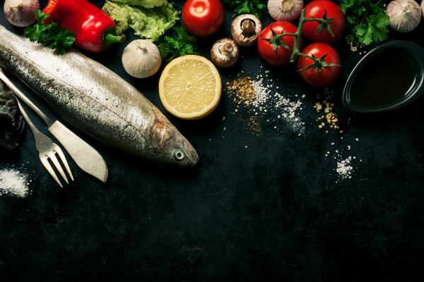fish with vegetables on a black background - Треска, маринованная с чесноком, постный стол
