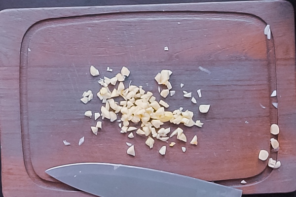 flat lay step by step dicing organic garlic on wood cutting board - Томатно-чесночный соус
