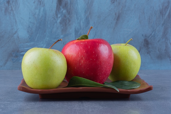 flavorful apples with leaves on wooden plate on the dark surface - Икра из баклажанов с яблоками