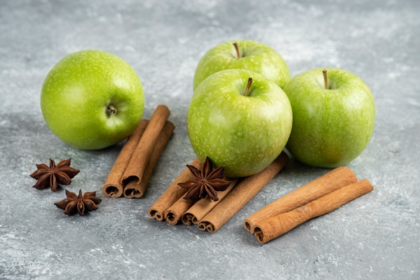 four green apple and cinnamon sticks on marble table - Кисель яблочный
