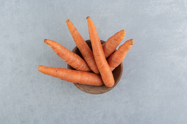 fresh carrots in the bowl on the marble - Каша пшённая с морковью