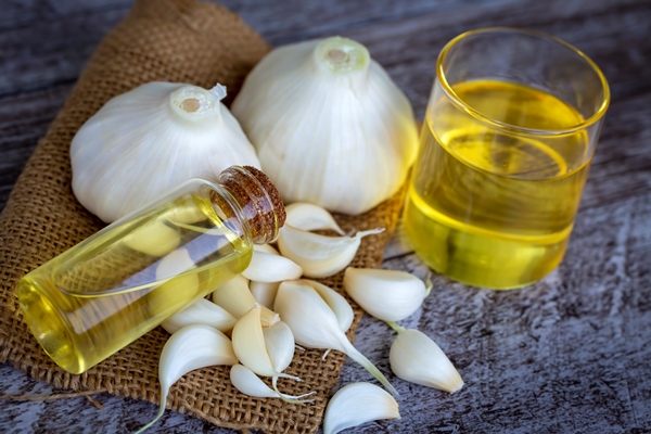 fresh healthy garlic oil on the wooden background - Салат из одуванчиков по-итальянски