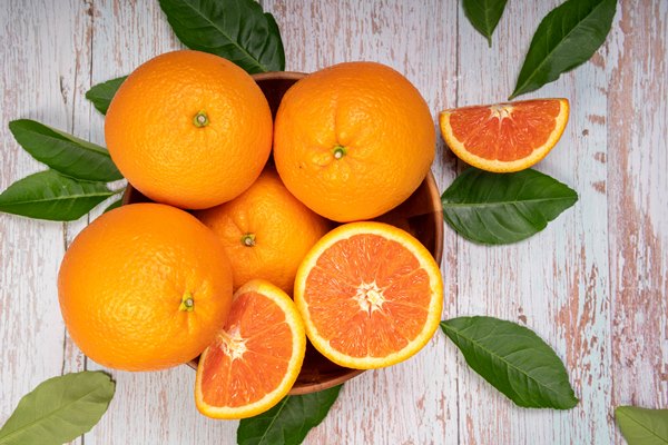 fresh orange fruit with orange slices and leaves in wooden background - Рис холодный с апельсинами
