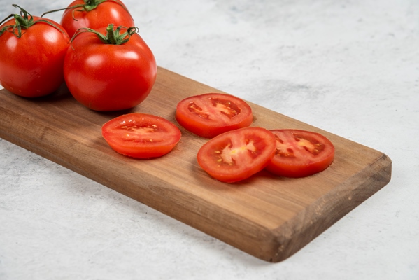 fresh red tomatoes on a wooden cutting board - Бутерброд с помидором, рыбой и авокадо