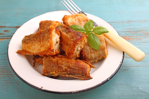 fried hake fish in a white plate - Треска, маринованная с чесноком, постный стол