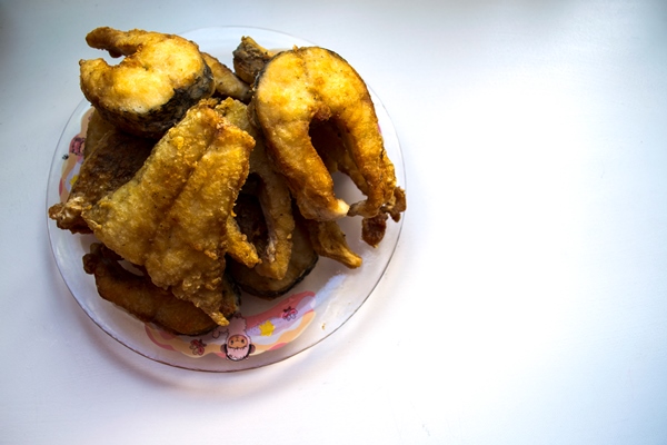 fried pike pike fish fried fish on a white plate - Рыба жареная или печёная
