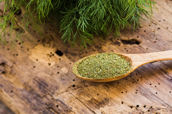 from above view fresh dill sprigs with wooden spoon full of dried and milled dill on wooden board horizontal closeup photo of homemade dill seasoning on old crannied surface - Грибная подливка