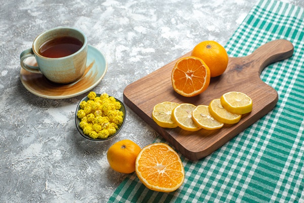 front view fresh lemon slices with candies and cup of tea on light surface - Апельсиновый чай