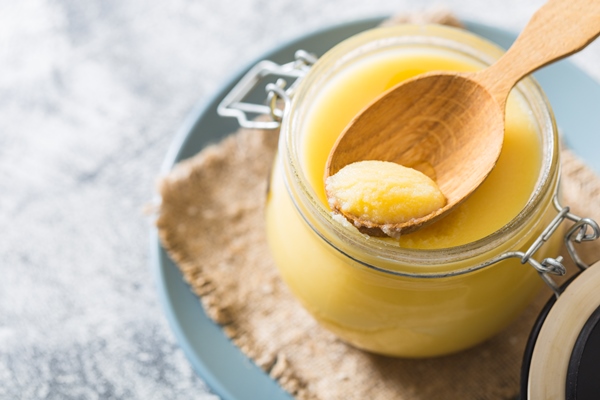 ghee or clarified butter in jar and wooden spoon on gray table top view copyspace ghee butter have healthy fat and is a common cooking ingredient in many of the indian food 1 - Сныть с тушёным картофелем