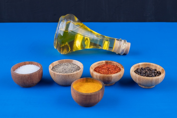 glass bottle of extra virgin oil and various spices on blue surface - Котлеты архиерейские