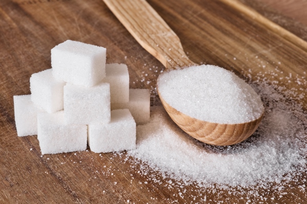 granulated sugar in wooden spoon and sugar cubes stacked in pyramid on wooden background - Квас из земляники
